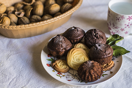 Illustrationsbild. Ein Teller mit Muffins und Plätzchen
